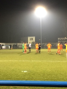 AFC Fylde players surround the referee after a first-half penalty is awarded.